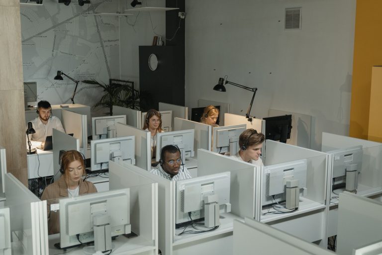 Equipe diversa de atendimento ao cliente trabalhando em um moderno call center.
