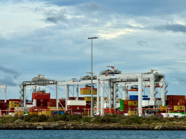 Terminal portuário automatizado com guindastes e contêineres para movimentação de cargas.
