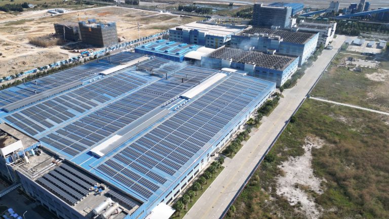 Eco Invest Brasil direciona R$ 49,95 bilhões a seis cadeias de inovação Vista aérea de painéis solares instalados sobre um complexo industrial.